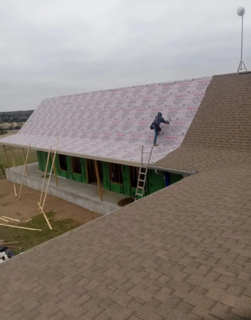 Worker preparing underlayment for a metal roof installation in Edgewater Park